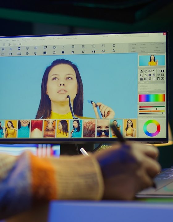 Male graphic artist using essential digital tools on dual monitors, professional design work showcasing modern setup at home. Editor designer showing advanced photo editing skills. Camera B.