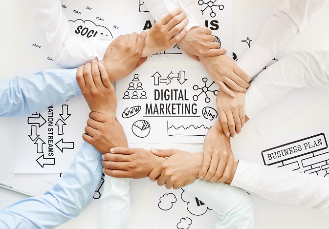 Business team making ring of hands above digital marketing drawing